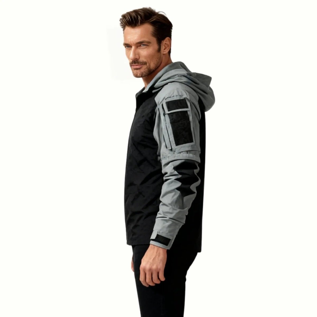 Side profile of a male model in the Kouvr Clint Tactical Anorak, highlighting the grey sleeve panels and utility pockets.