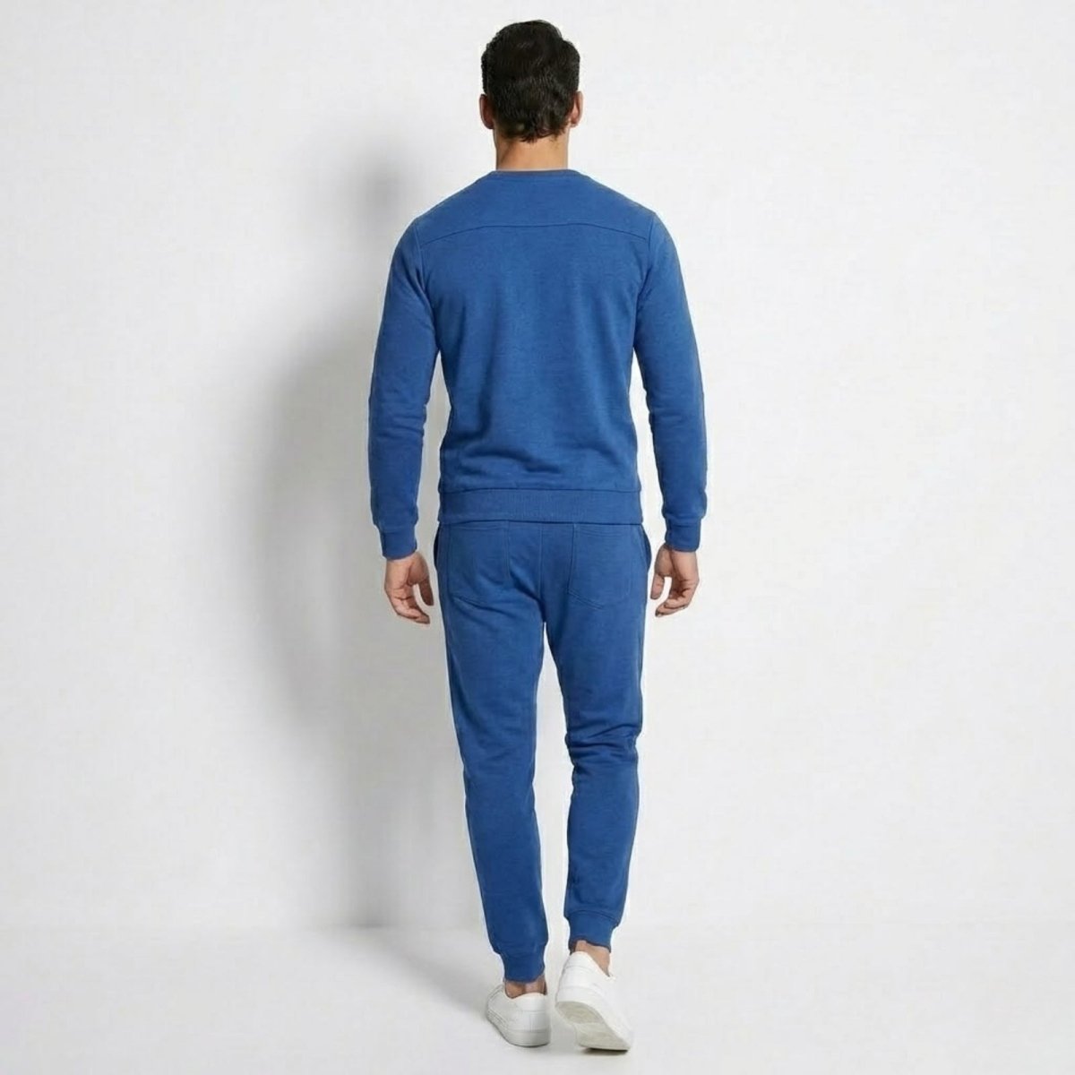 Back view of the Kouvr Crue men's blue sweatsuit, highlighting the clean lines and shoulder detailing of the sweatshirt.