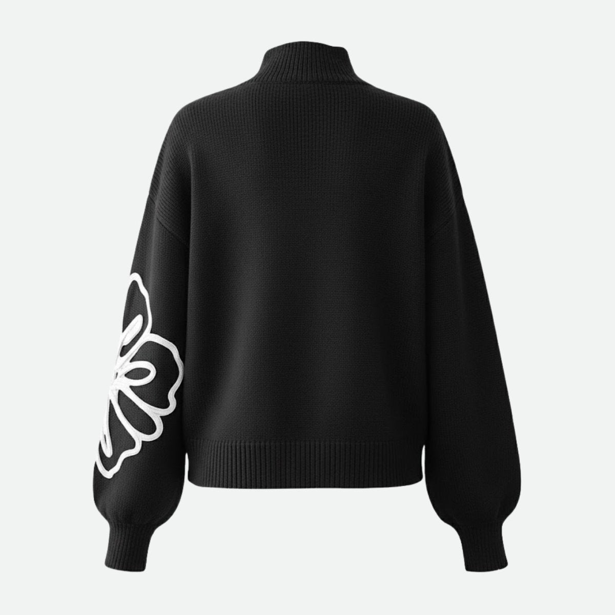 Back view of the Kouvr Cynthia sweater laid flat, showing the clean back and the continuation of the floral embroidery on the sleeve.