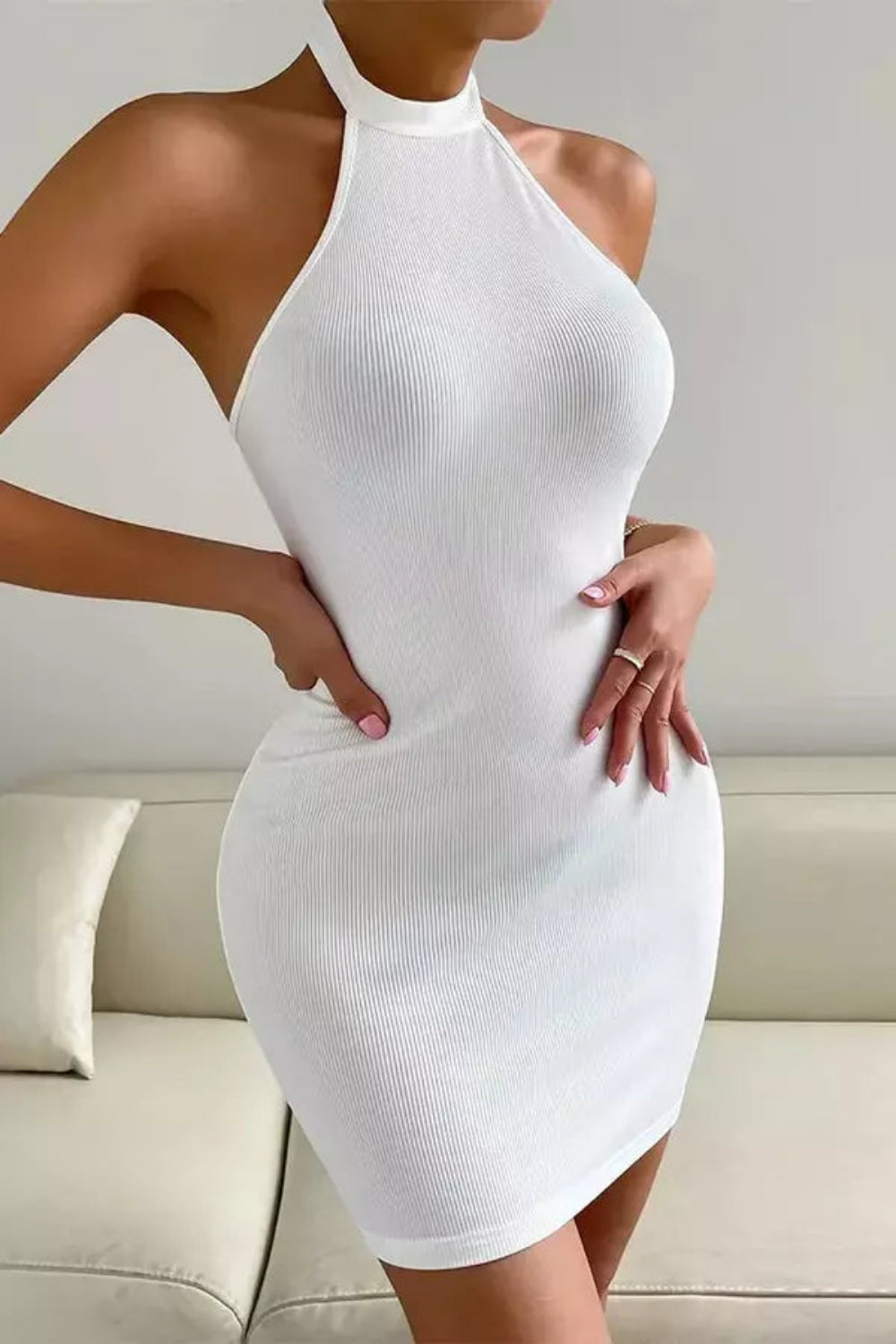 Model wearing the Kouvr Cyrill form-fitting white ribbed halter dress from the back