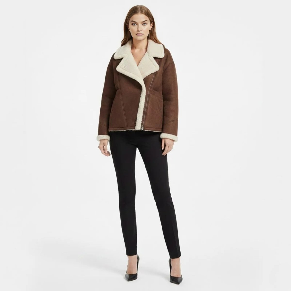 Model wearing the Kouvr oversized dark brown faux shearling aviator jacket with black pants and heels, front view.