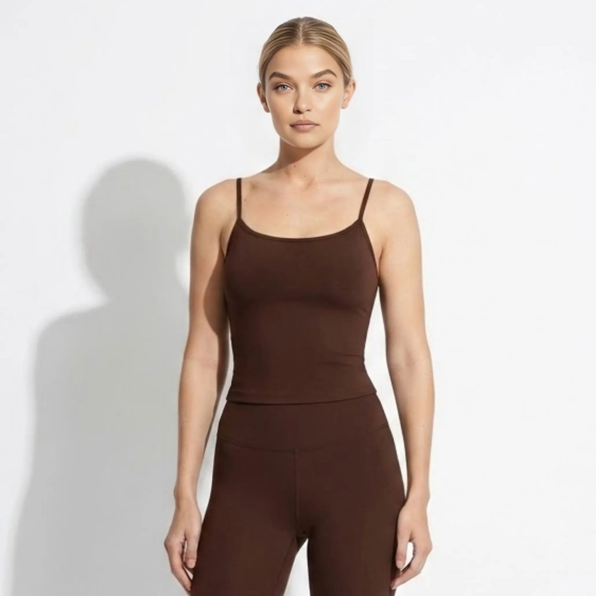 Woman wearing Kouvr dark brown racerback cami tank top and matching leggings in front view