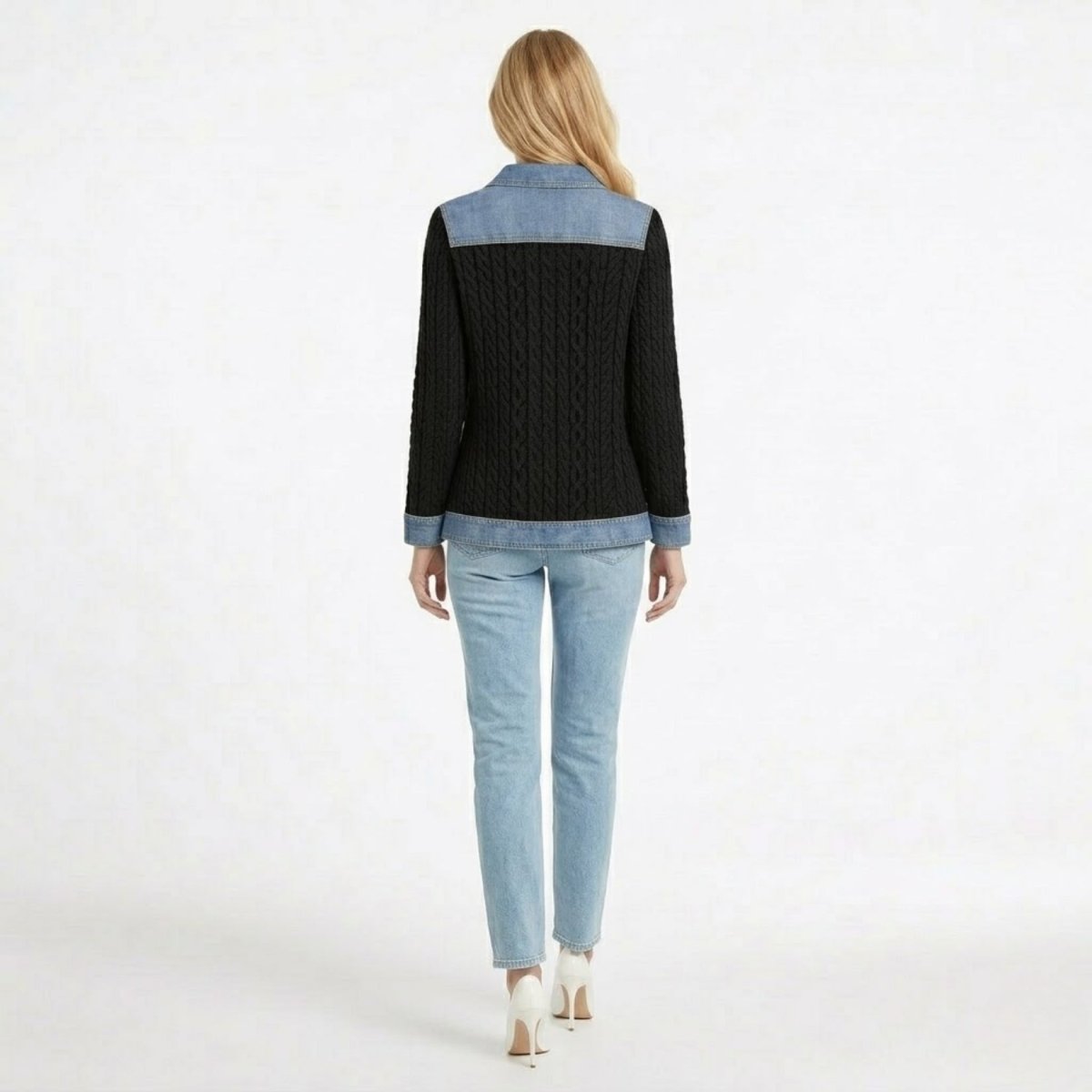 Back view of women's black cable knit sweater jacket featuring a denim shoulder yoke and light wash denim hem.