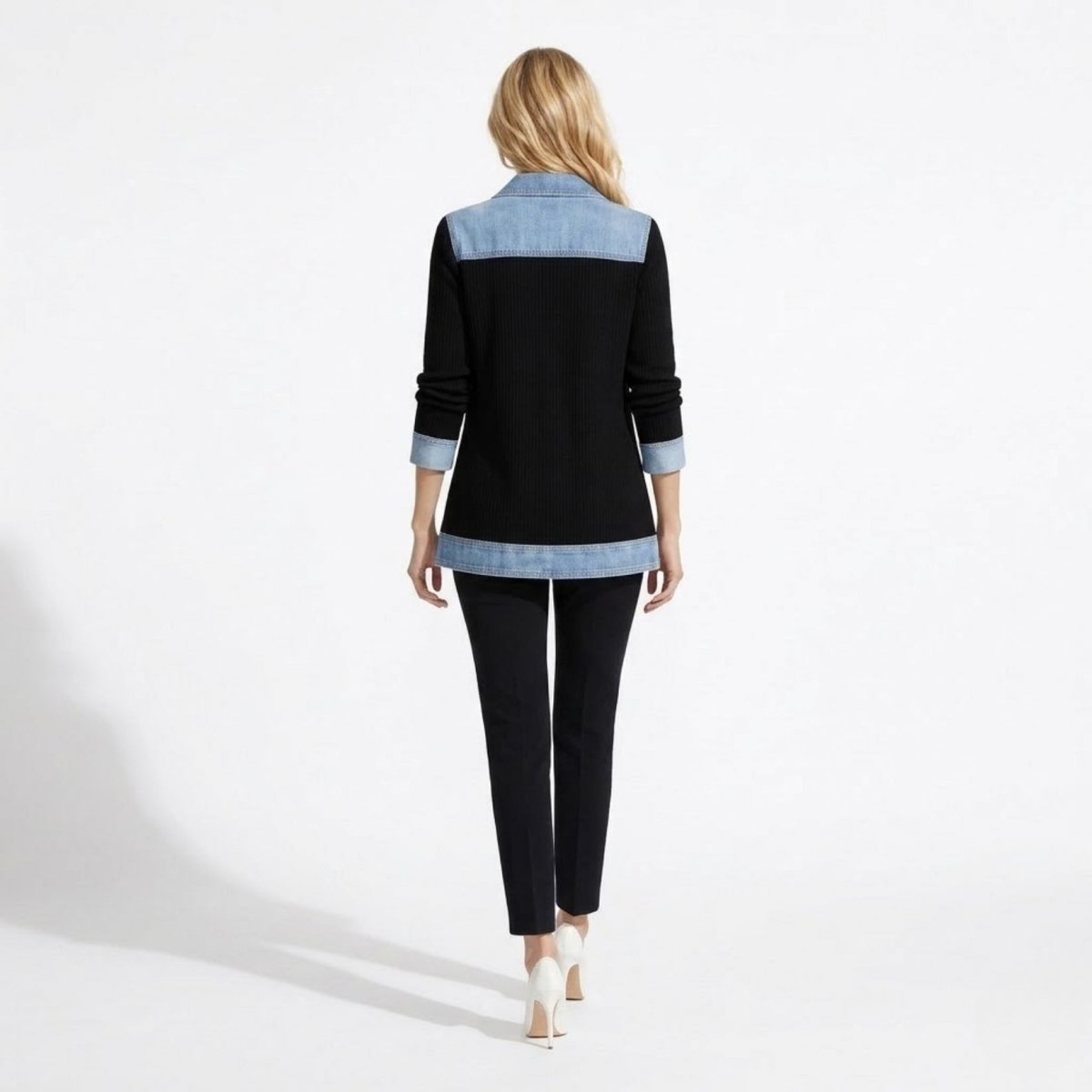Back view of the Kouvr black ribbed knit jacket featuring a structured blue denim yoke and contrast hemline.