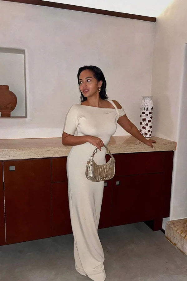 Naturally include related terms like `sculptural silhouette`, `figure-hugging`, `single sleeve gown`, `elegant formalwear`, and `resort evening dress