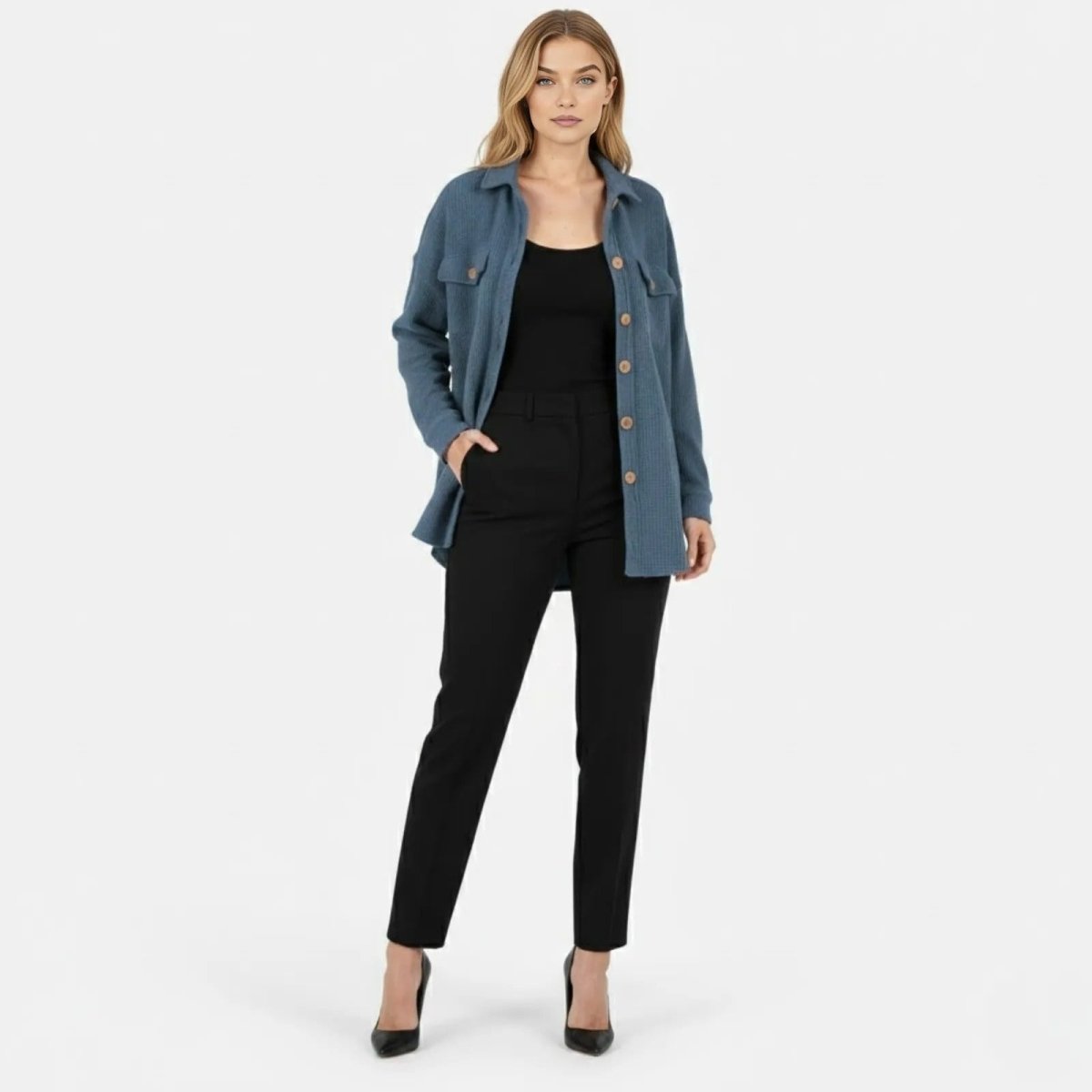 Model wearing the Kouvr oversized donna knit shacket in slate blue, styled open over a black top and trousers.