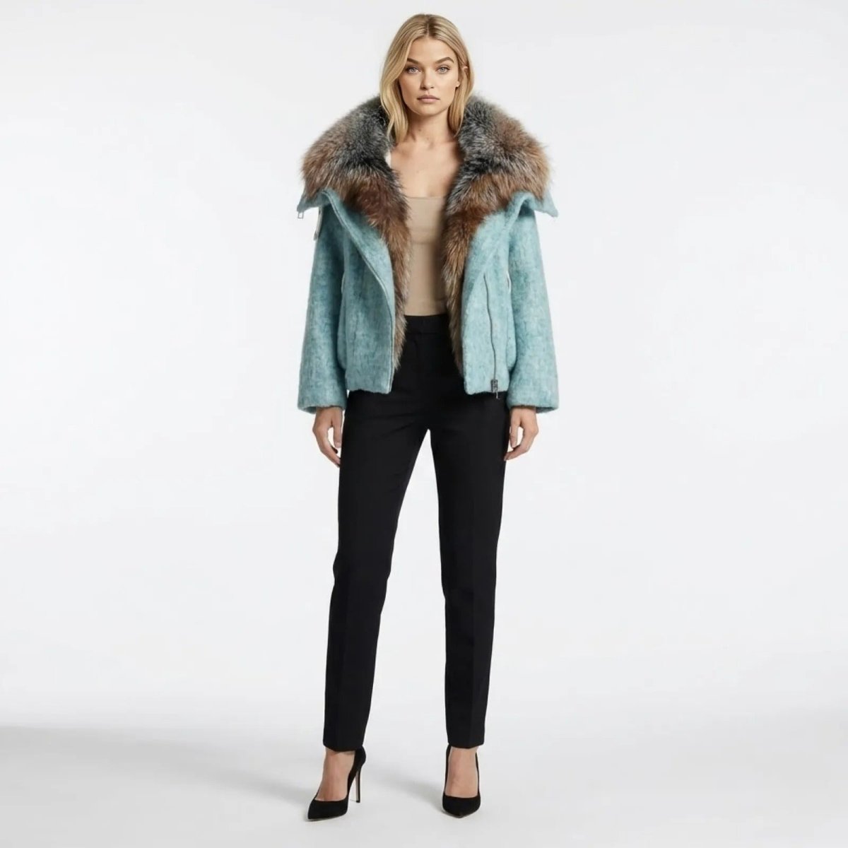Model wearing the Kouvr Dorothy light blue wool bomber jacket with an oversized fox fur collar, styled with a nude camisole and black trousers.