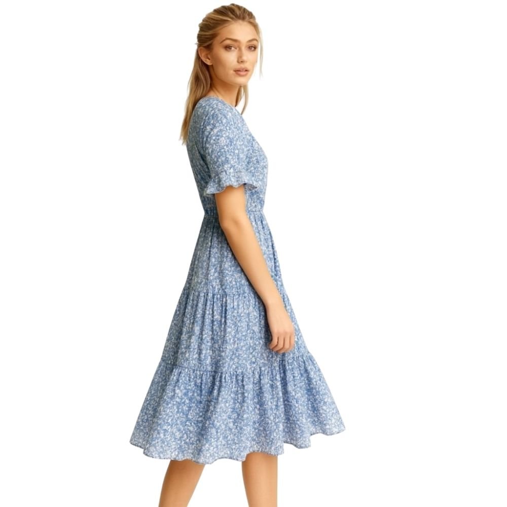 Woman wearing a kouvr blue floral dress on a white background