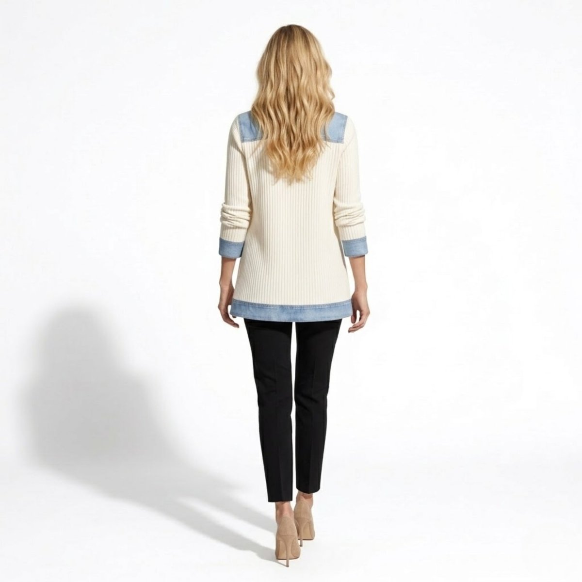 Back view of cream knit long cardigan showing denim shoulder yoke and structured hem styling on blonde model