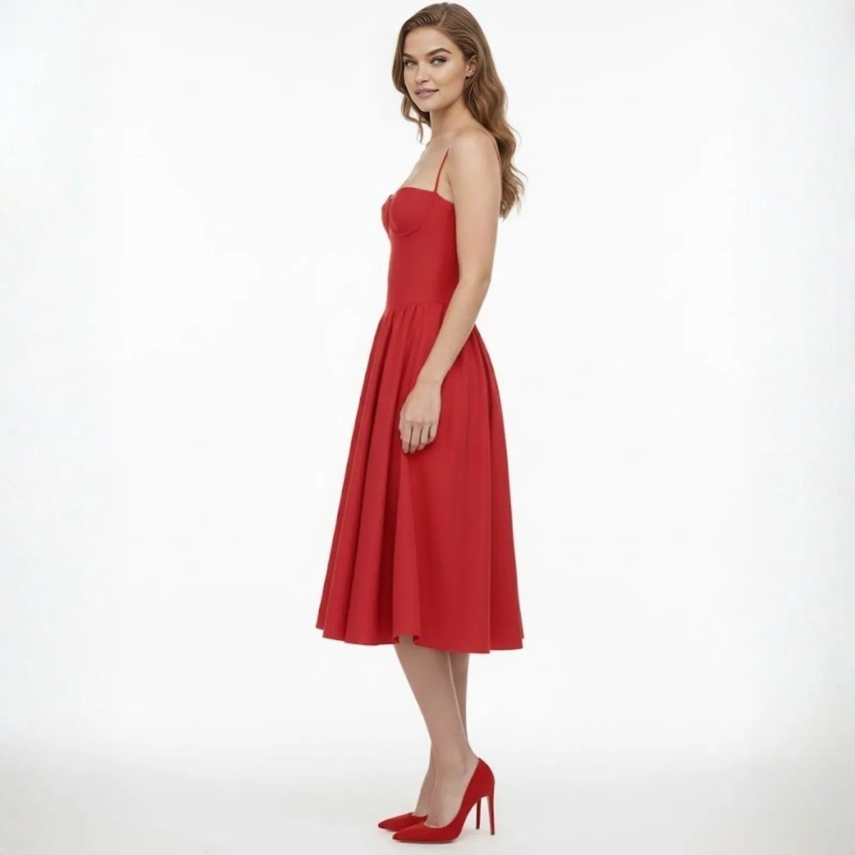 Side profile of a model in the Kouvr Evdokia red A-line midi dress showcasing the fitted corset bodice and flow of the full skirt.