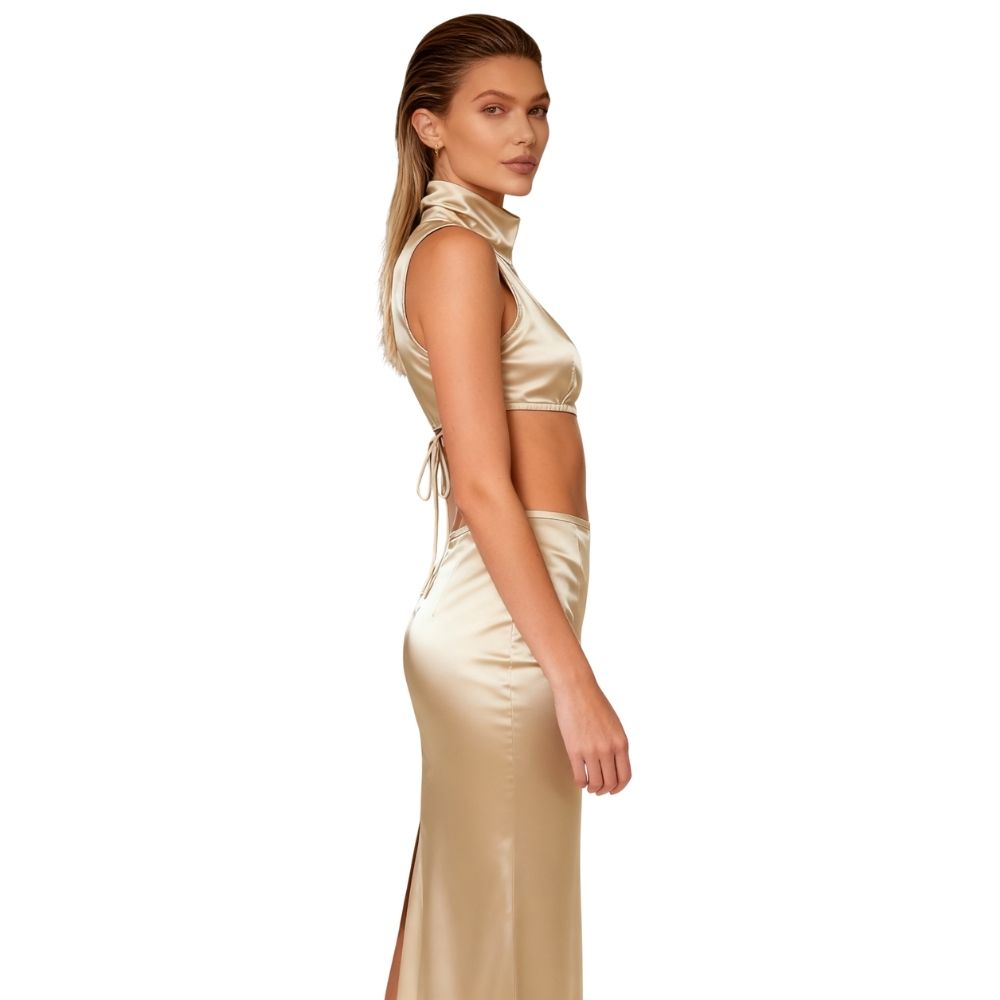 Woman wearing a gold kouvr satin dress on a white background