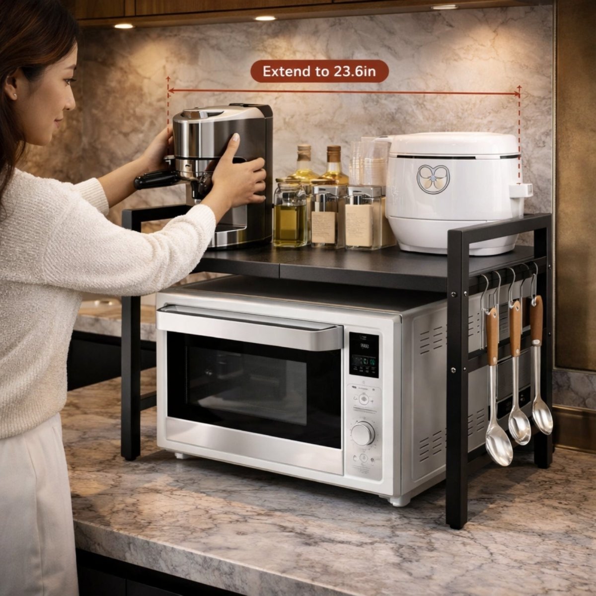 A woman placing a coffee machine on the black Kouvr expandable baker's rack, fully extended to 23.6 inches over a microwave.