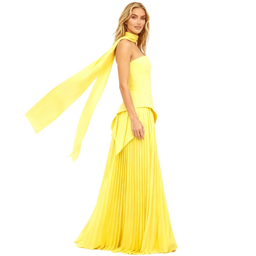 Yellow Kouvr evening gown with a long train on a white background