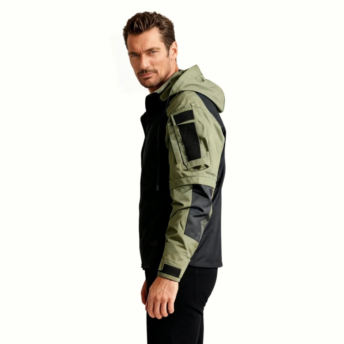 Side profile of the Kouvr Fashion Clint men's tactical jacket in dark green, highlighting the ripstop sleeve construction and utility patch panels.
