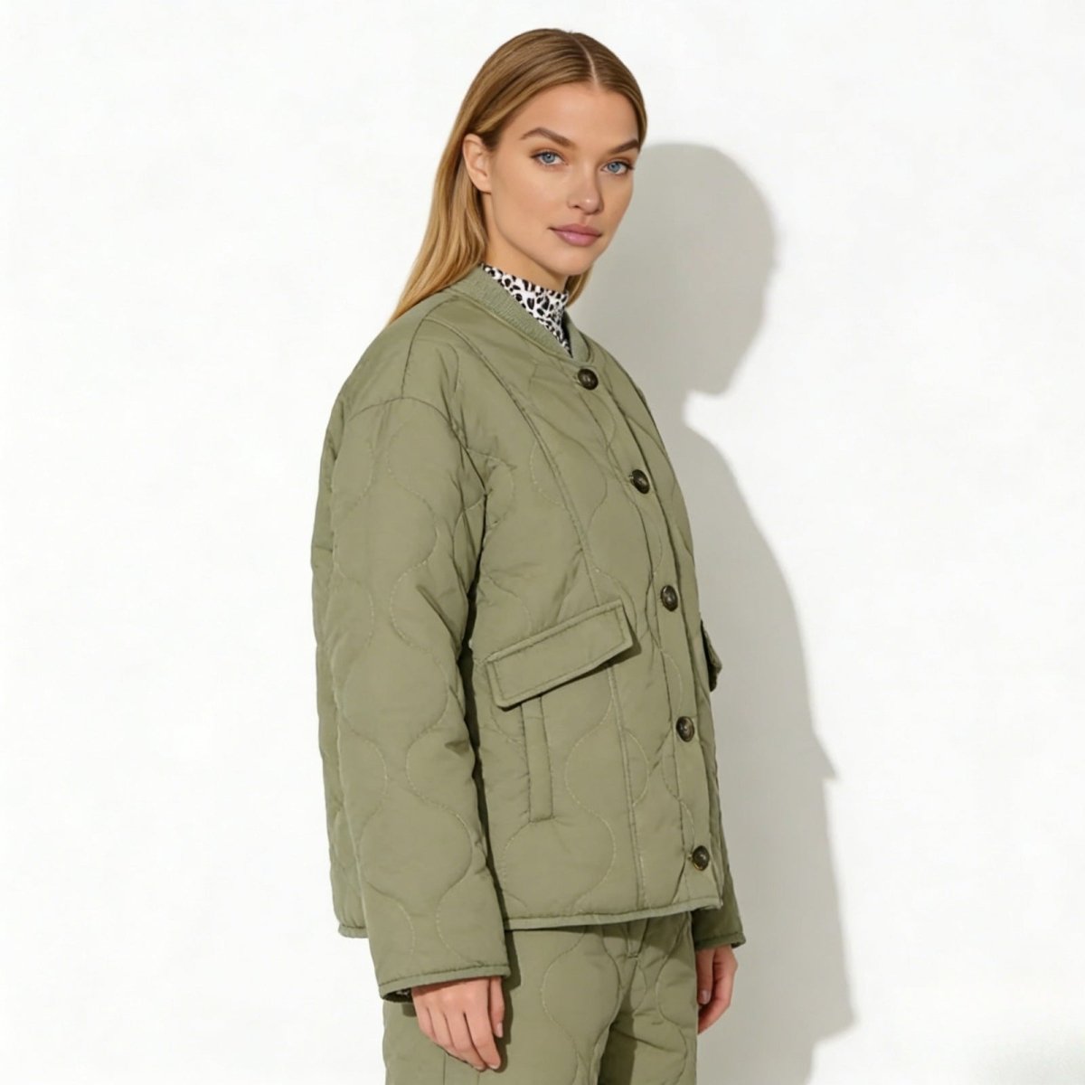 Side profile of a woman wearing the army green oversized quilted jacket from Kouvr Fashion, showing its boxy fit and pocket detail.