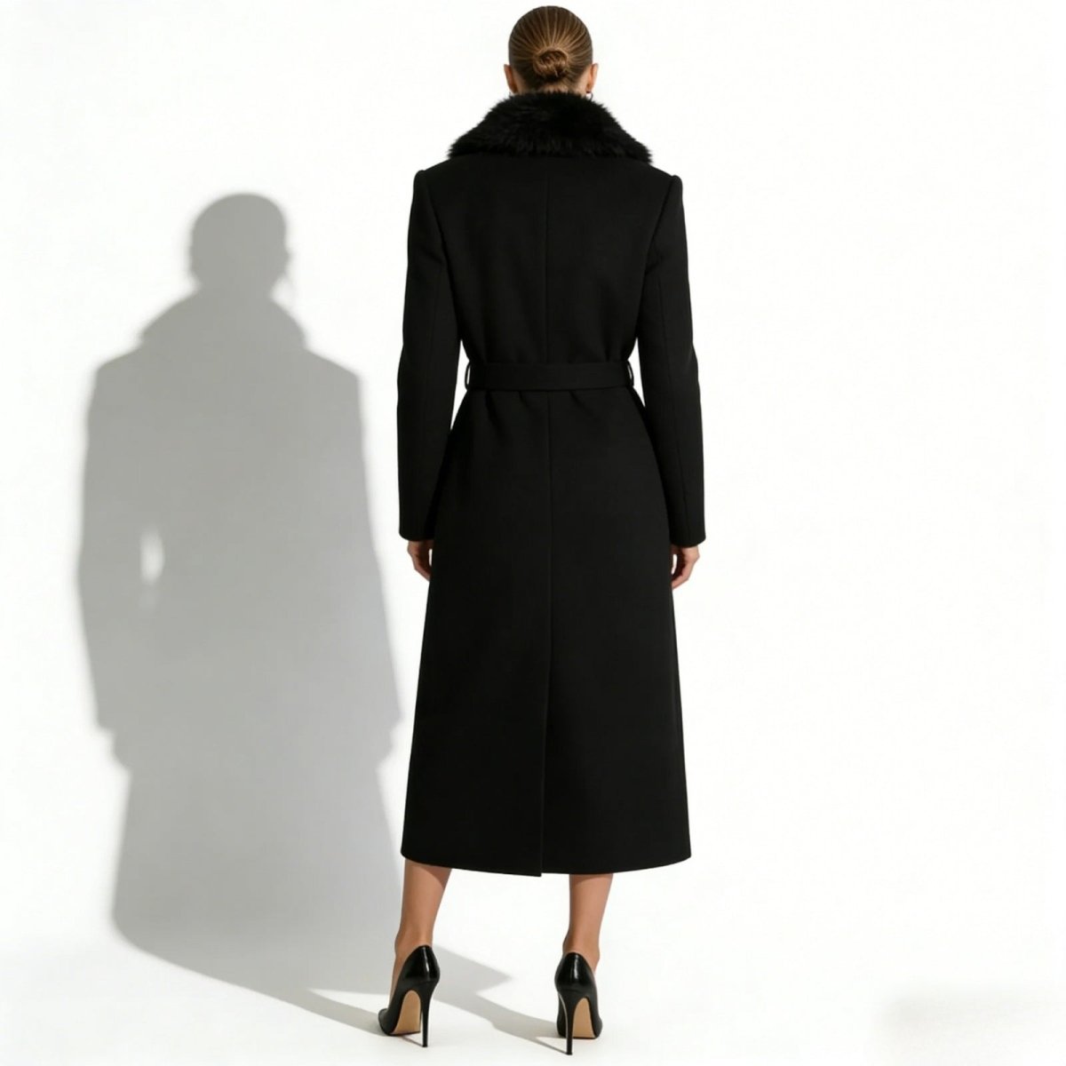 Back view of a model wearing the Kouvr Fashion black wool maxi coat, showing the tailored fit and self-tie belt.