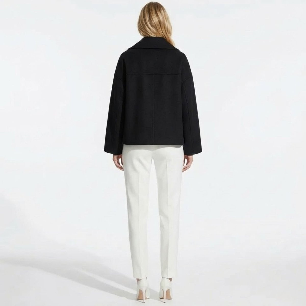 Back view of the Kouvr Fashion black cropped wool peacoat, displaying the central seam and shoulder structure.