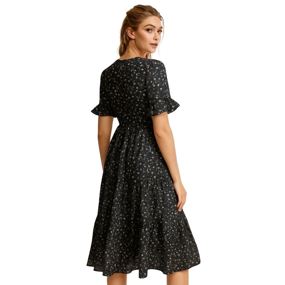 Woman wearing a black kouvr floral dress on a white background