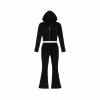Flat lay of the black knit matching set from Kouvr Fashion, including the cropped zip hoodie and flared pants with asymmetrical waistband detail.