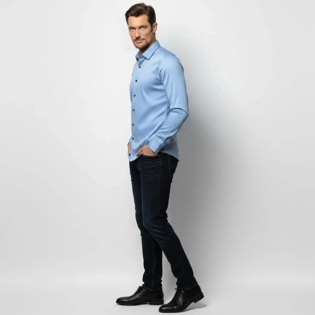 Side profile of a male model in a light blue stretch business casual shirt by Kouvr Fashion, highlighting the athletic, tailored fit.
