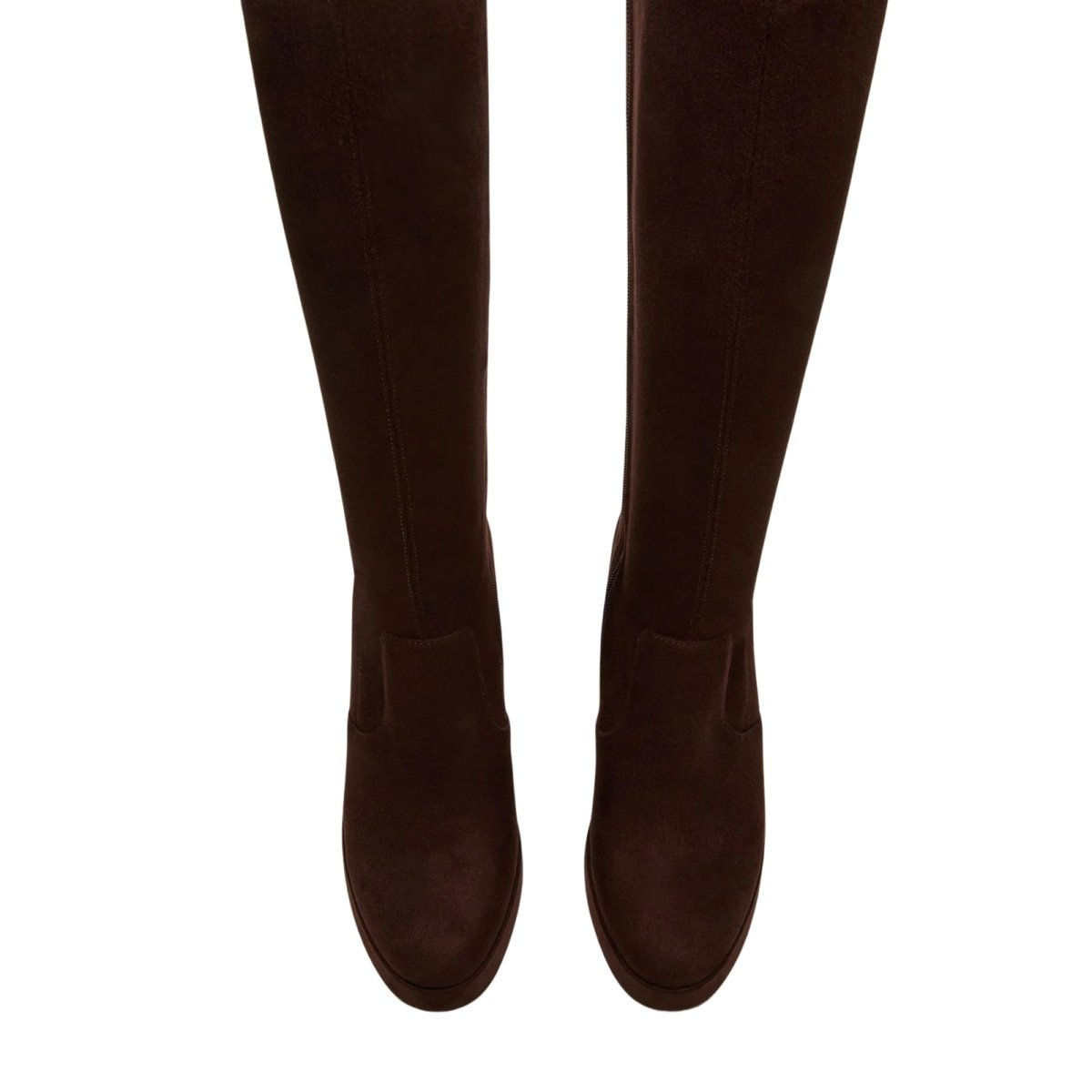 Brown Kouvr ankle boots worn with dark pants on a white background