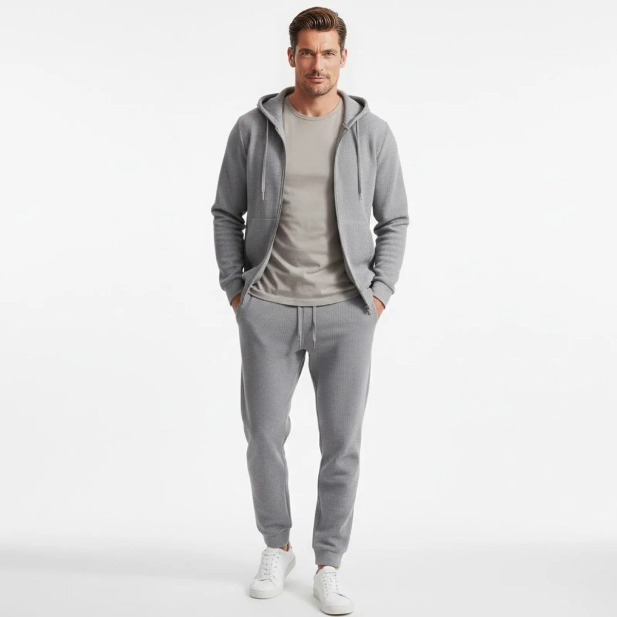 Model wearing the grey waffle-knit Case lounge set from Kouvr Fashion, including a zip hoodie and matching slim-fit joggers, shown from the front.