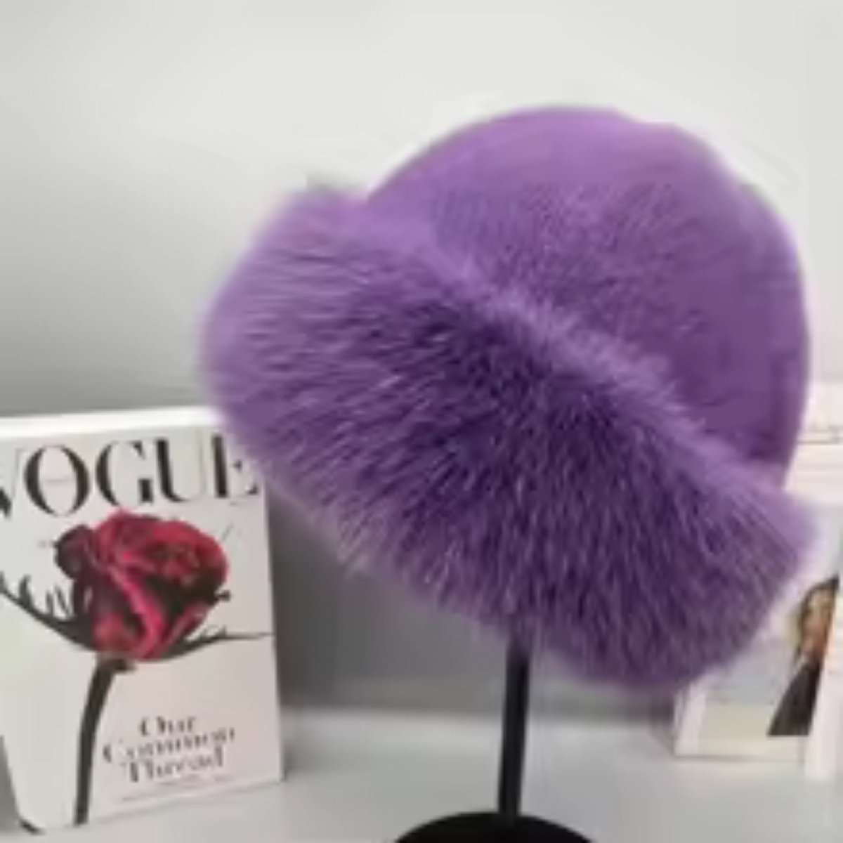 Purple fur headband on a stand with a Vogue magazine in the background