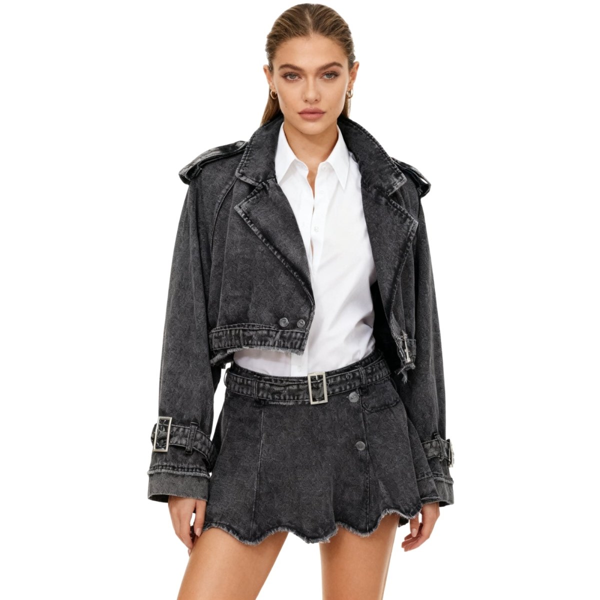 Woman wearing a black kouvr denim jacket and skirt with a white shirt on a white background