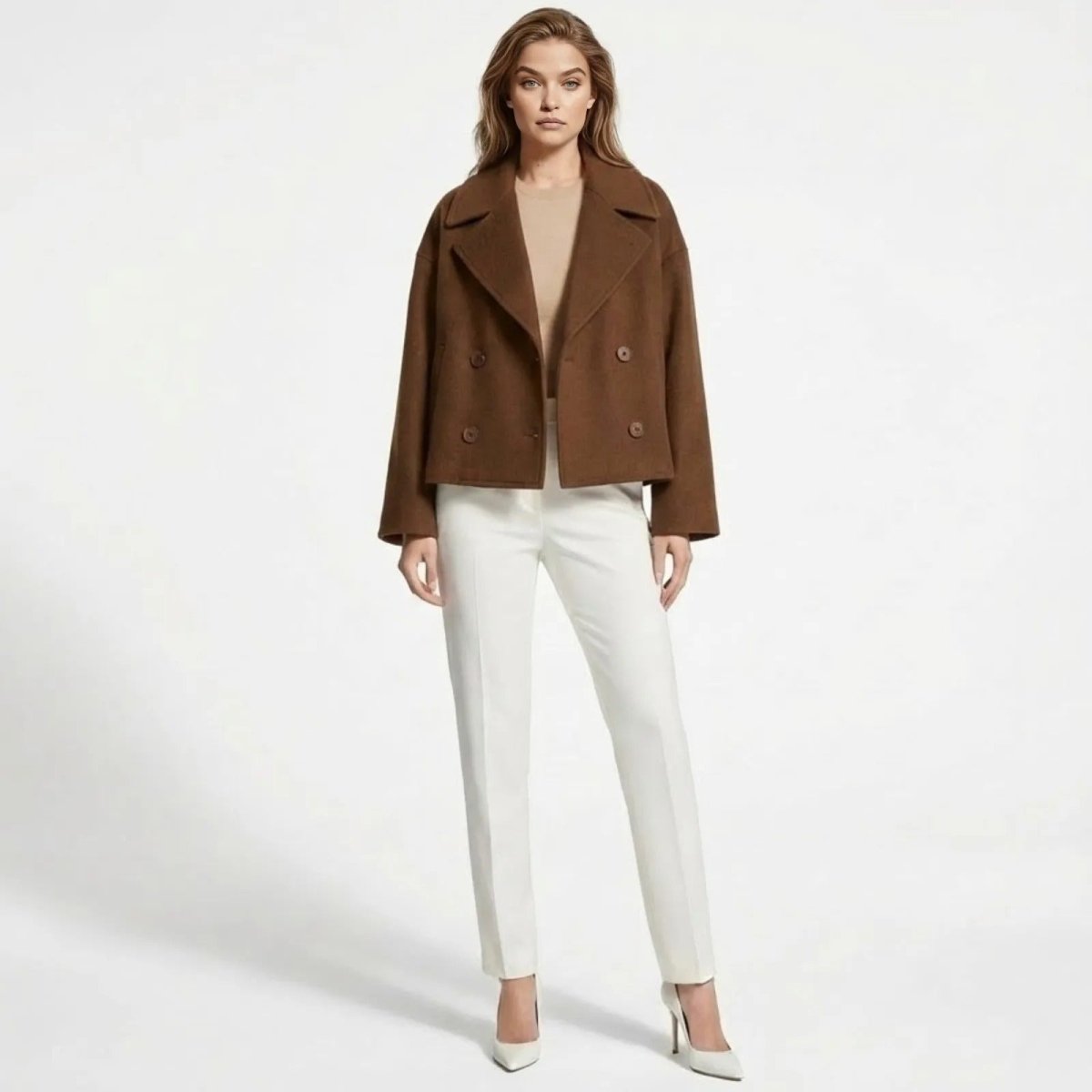Model wearing the Kouvr Fashion cropped double-breasted wool jacket in cognac brown paired with white tailored trousers.