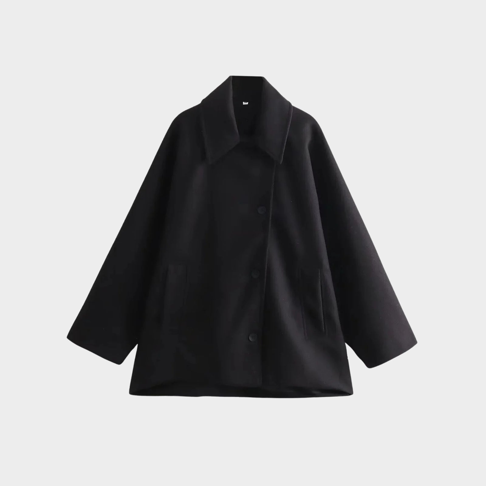 Flat lay of the front of the Kouvr Fashion oversized double-breasted wool peacoat in black, showing the button details and wide lapels.