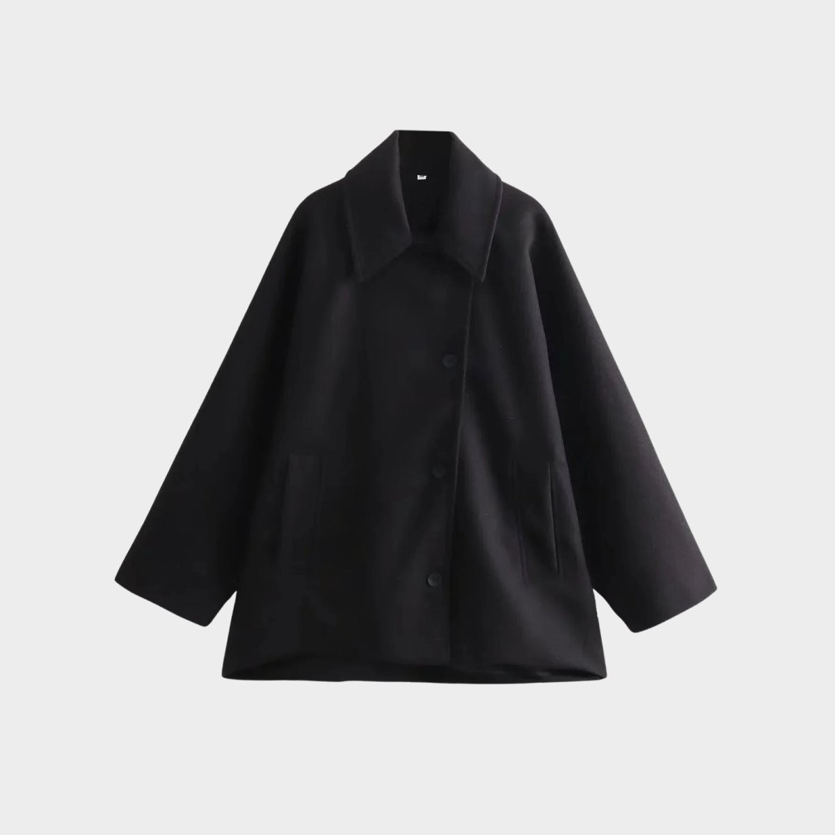 Flat lay of the front of the Kouvr Fashion oversized double-breasted wool peacoat in black, showing the button details and wide lapels.