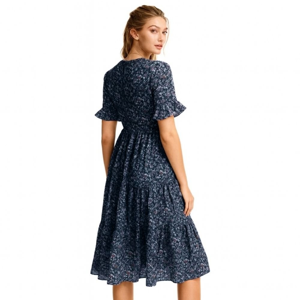 Woman wearing a kouvr navy floral dress on a white background