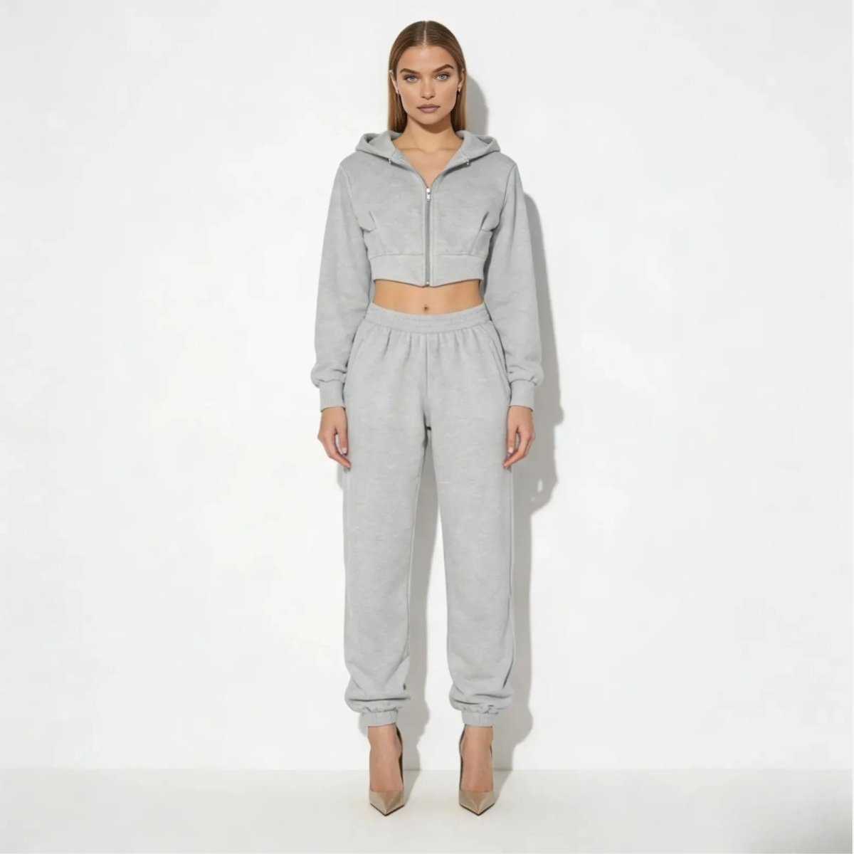Model wearing the Kouvr Fashion Ellaine two-piece sweatsuit in heather grey, featuring a cropped corset zip hoodie and high-waist joggers.