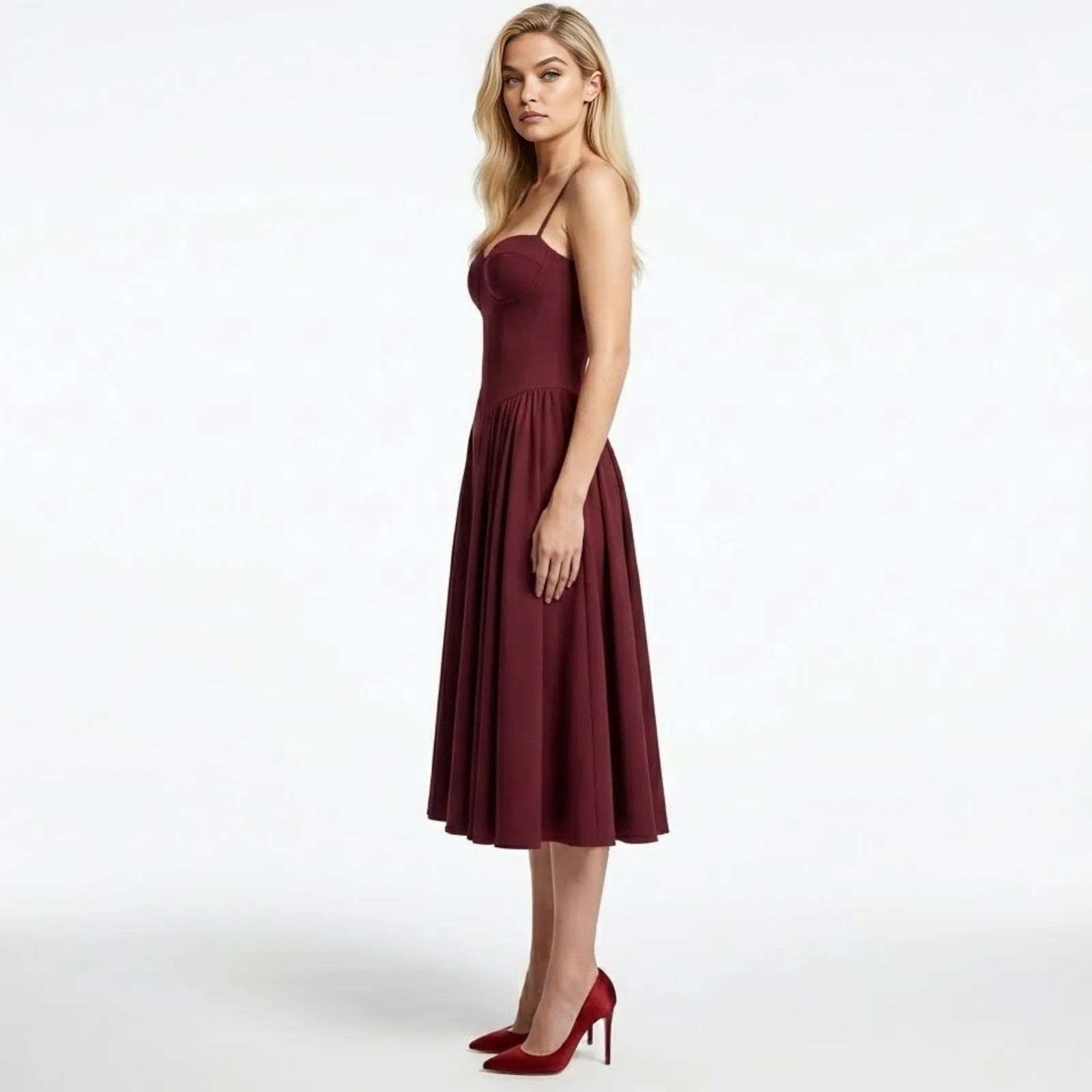 Side view of the Kouvr Fashion Evkodia midi dress in burgundy, showing the fitted corset bodice and pleated skirt silhouette.