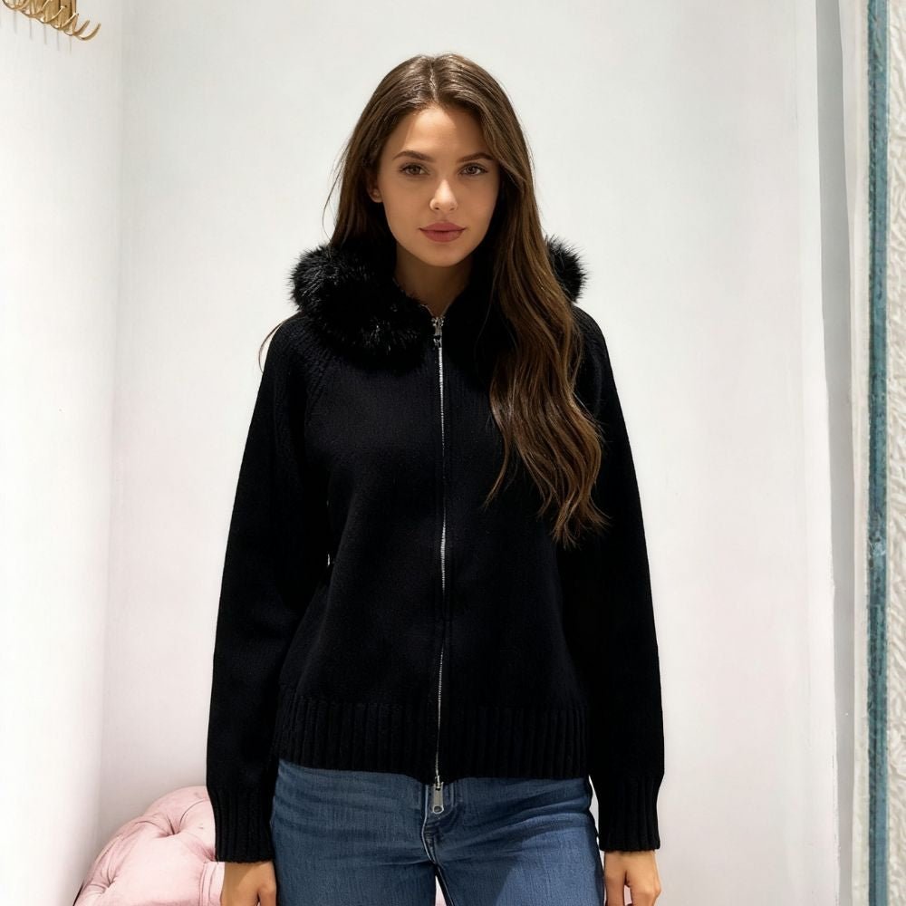 Woman wearing a black kouvr zip-up sweater with fur collar against a white background