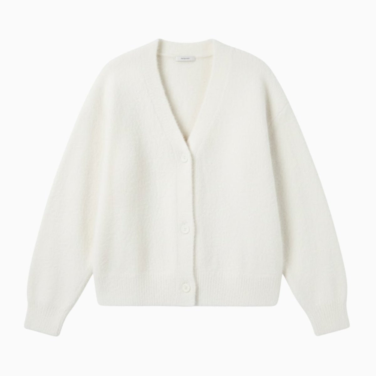 Flat lay product shot of the Kouvr Fashion white v-neck button-front cardigan, showing its soft, fluffy texture.