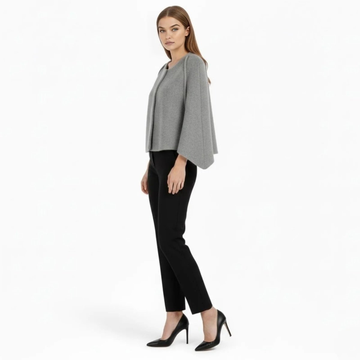 Side profile of a model in a grey collarless cape jacket by Kouvr Fashion, showcasing the flared sleeve silhouette.