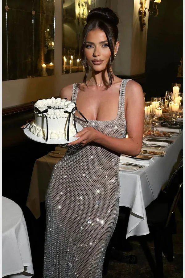 Model wearing the Kouvr Fashion Isabeu Gown, a silver floor-length rhinestone crystal mesh dress with a square neckline