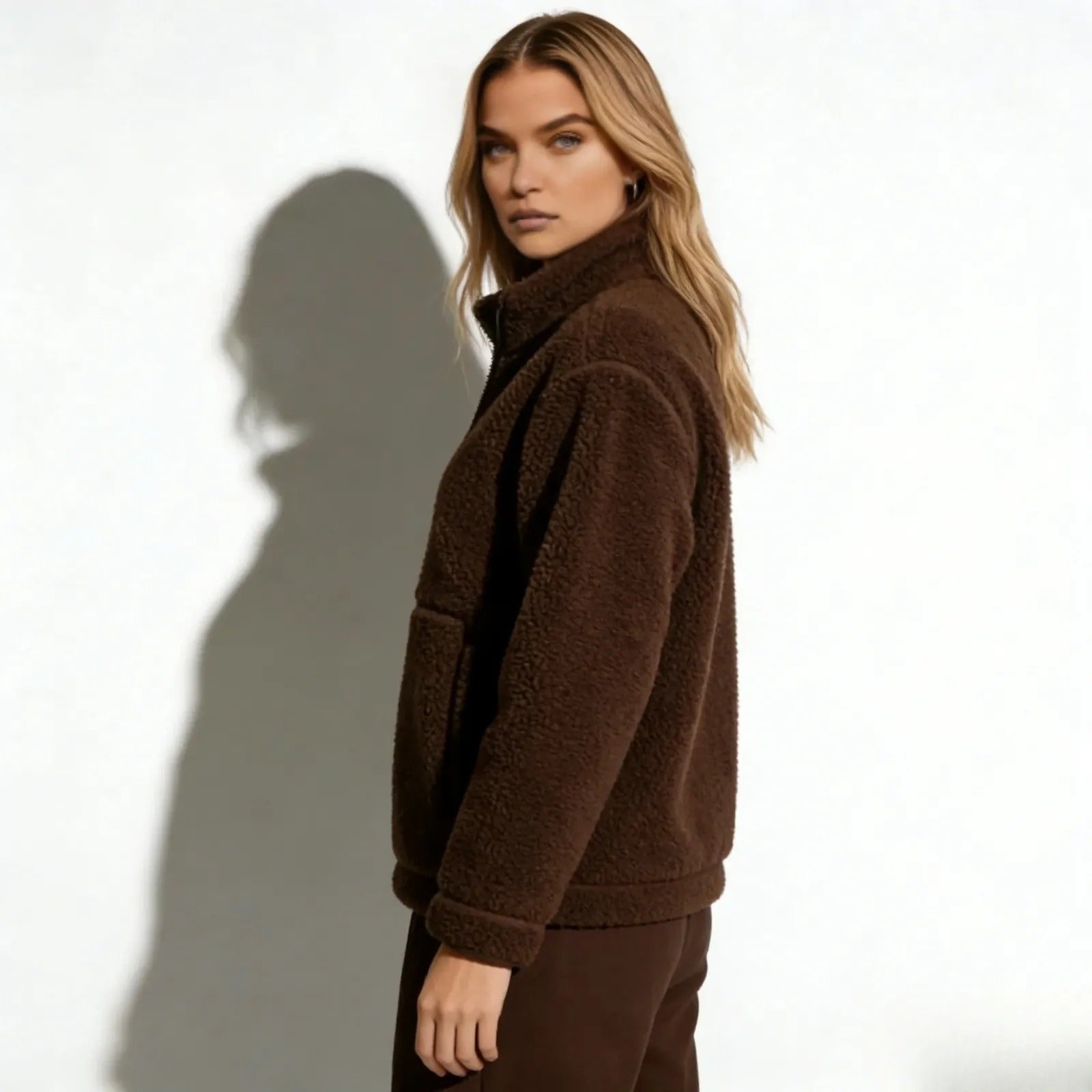 Side profile of a model wearing the high-neck Kouvr Fashion Julie Sherpa Fleece Jacket in dark brown to show its silhouette and fit.