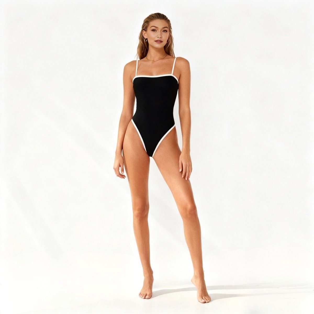 Woman wearing a black and white Kouvr swimsuit on a white background