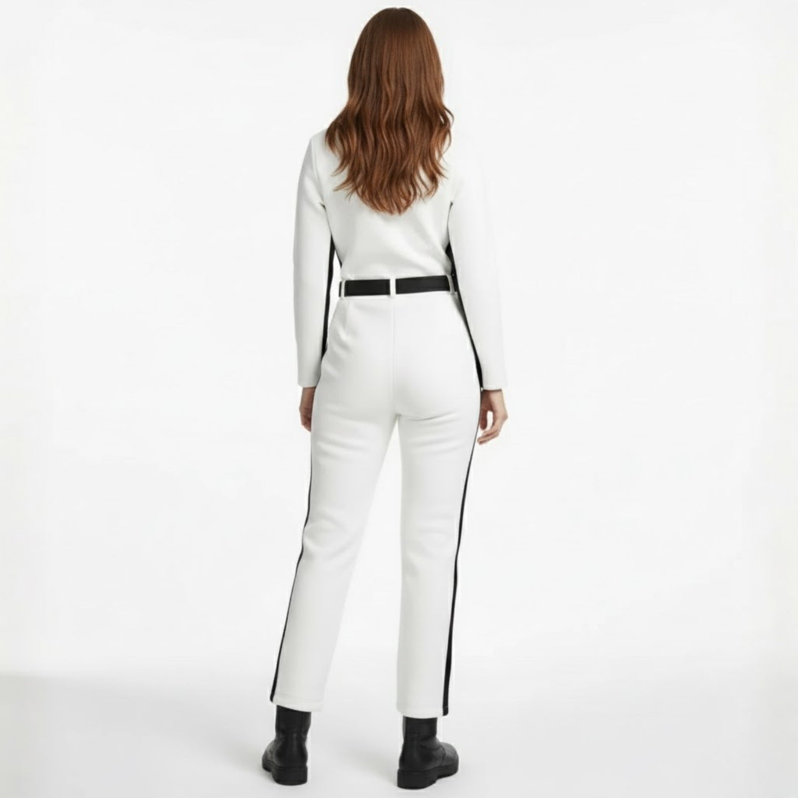 Back view of a model wearing the Kouvr Fashion Junnie white ski jumpsuit with a black belt.
