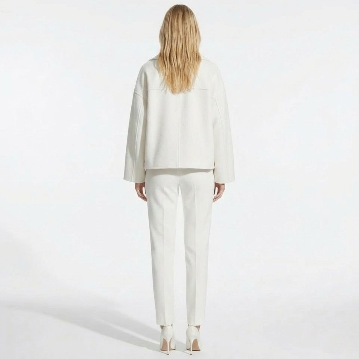 Back view of a model wearing the Kouvr Fashion Katherine white cropped jacket, highlighting the clean seam details and structured shoulders.