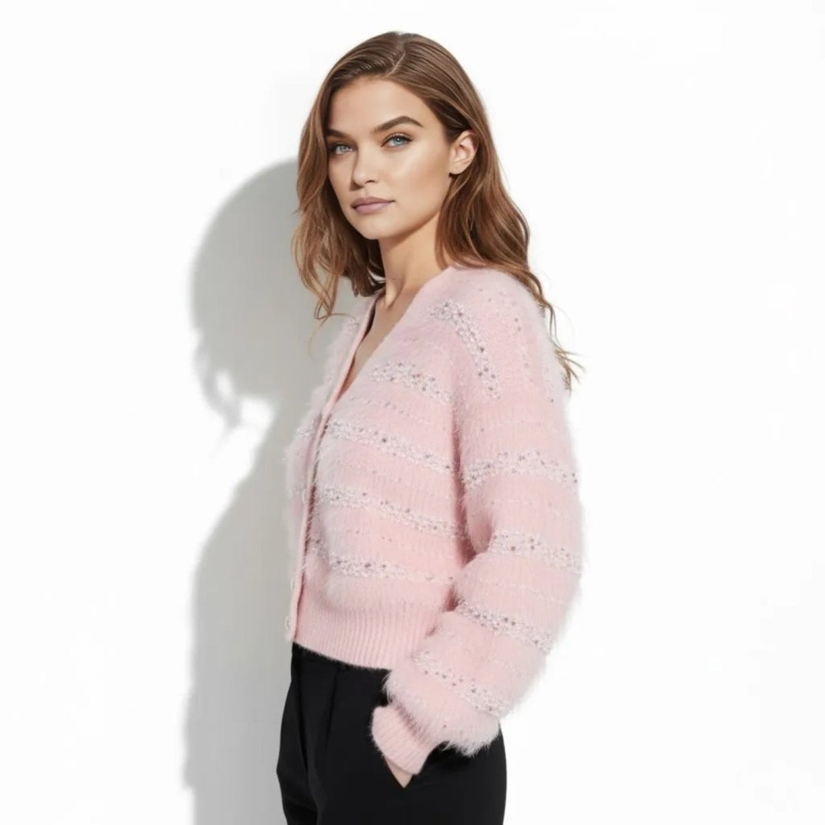 Side profile of a model wearing the embellished pink fuzzy v-neck cardigan, showing the blouson sleeve detail.