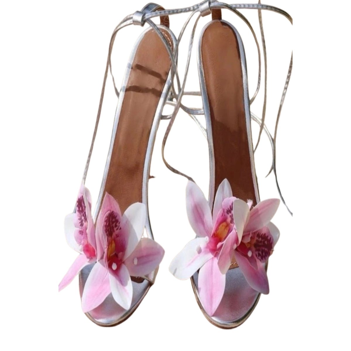 High-heeled shoes with pink floral decorations on a white background