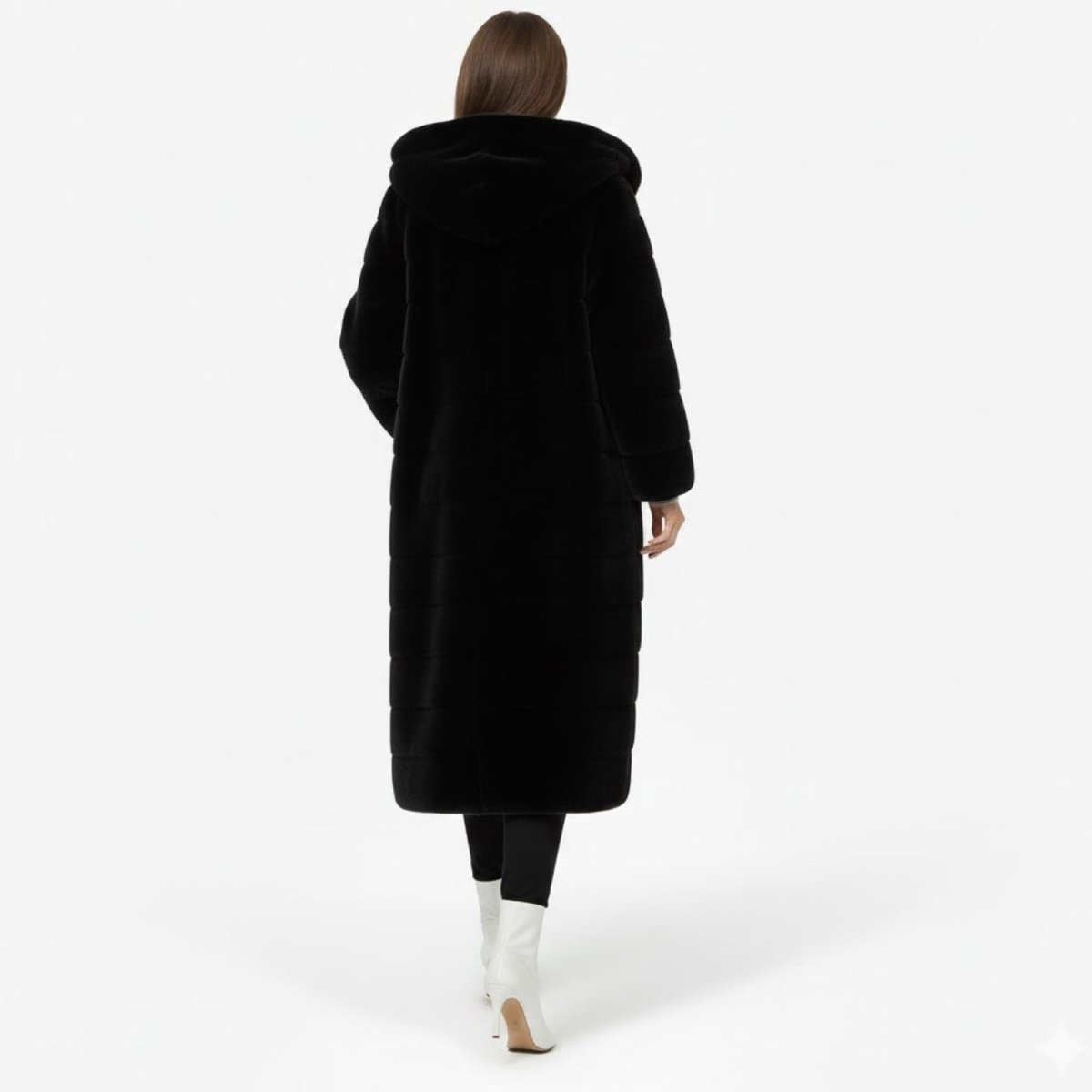 Back view of a model walking away in a long black faux fur coat with a large hood.