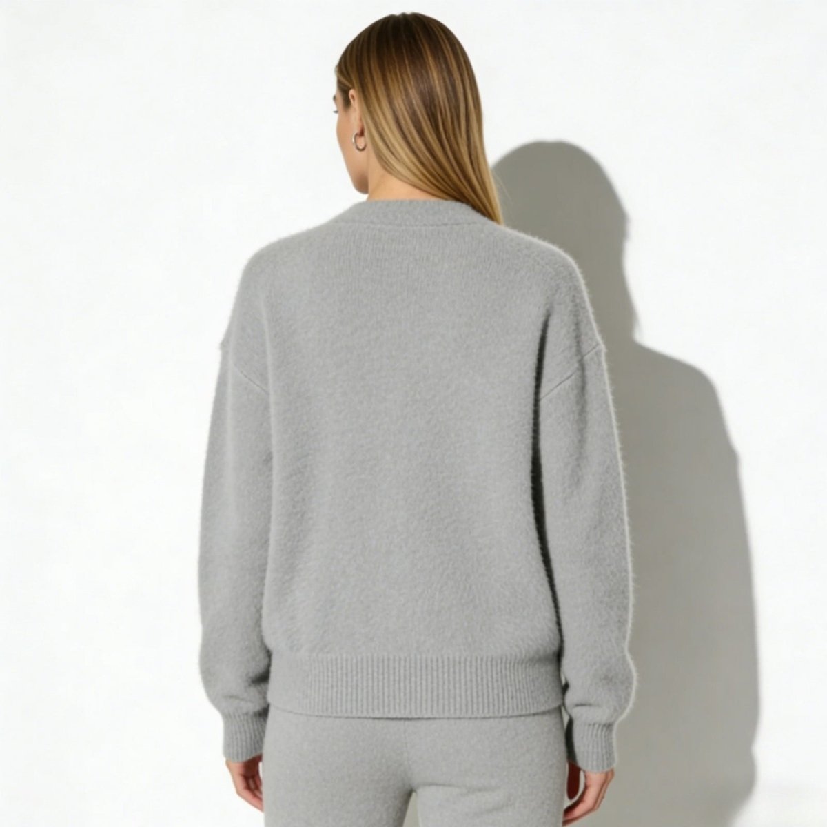 Back view of a model wearing the Kouvr Fashion soft heather grey alpaca v-neck cardigan.