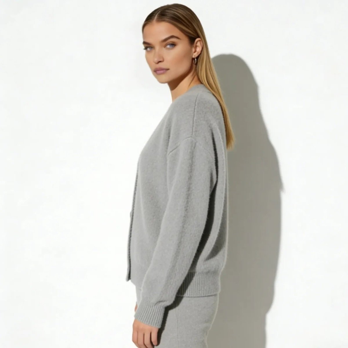 Model in a side profile wearing the Kouvr Fashion heather grey alpaca cardigan showing its relaxed fit.