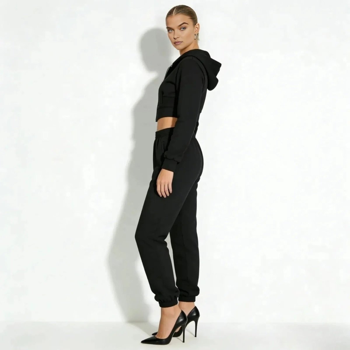 Model in a side profile view showcasing the fit of the Kouvr Fashion structured corset hoodie and jogger sweatpants set in black.