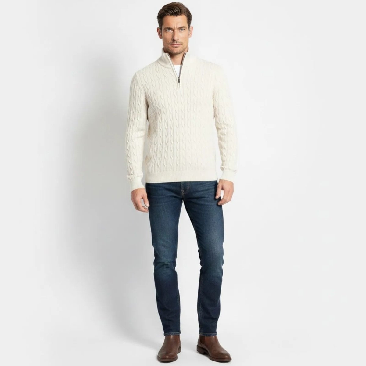 Male model wearing the Kouvr Fashion white cable-knit half-zip sweater with dark denim jeans, front view.