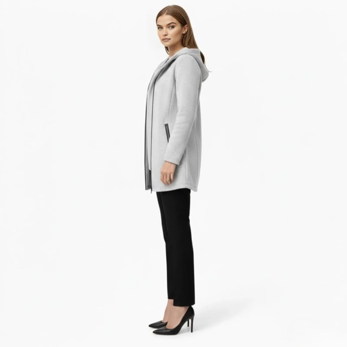 Side profile of a model in the Kouvr Fashion light grey hooded coat showing its streamlined silhouette and mid-thigh length.